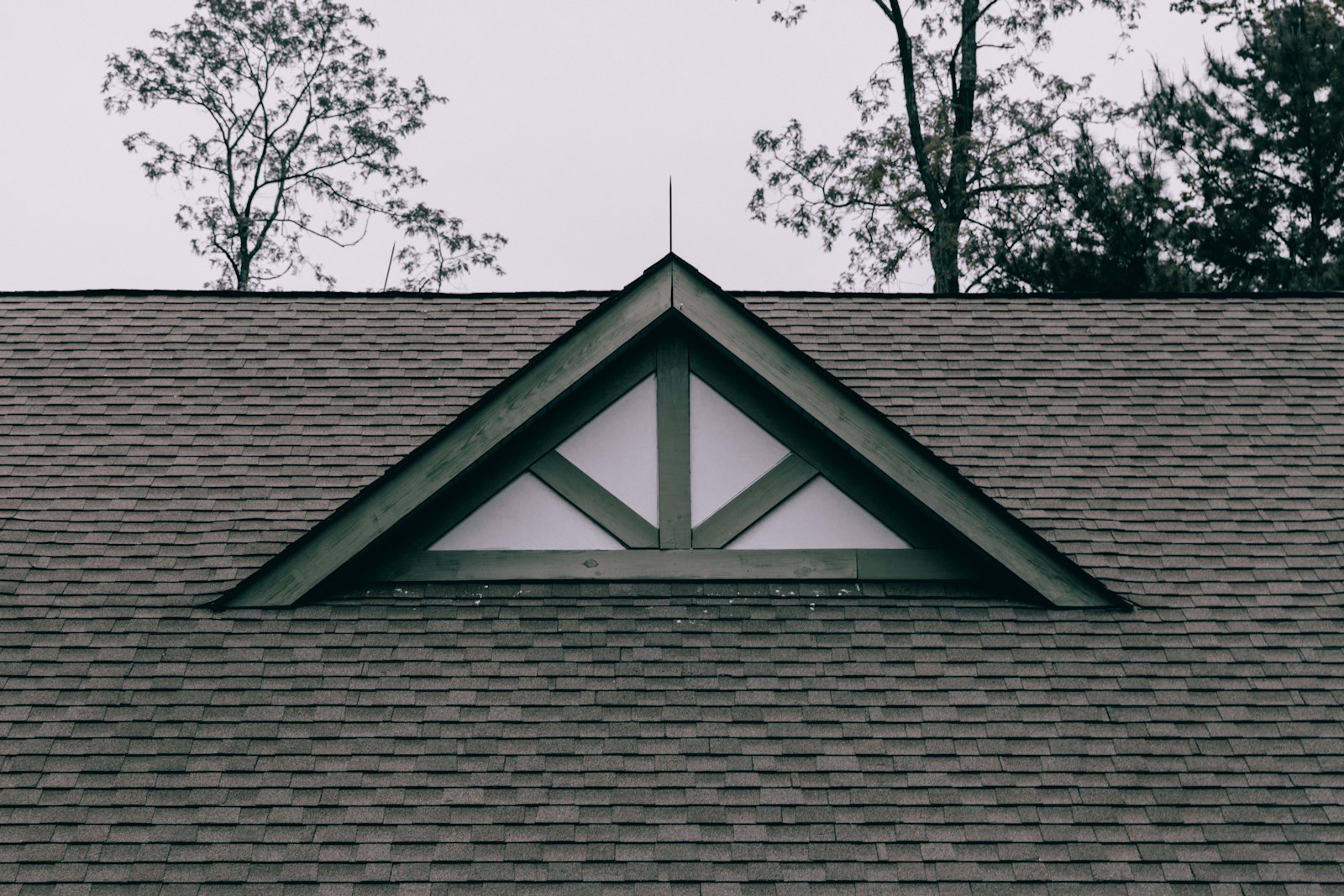 A roof of weathered architectural asphalt shingles framed by a gable truss.